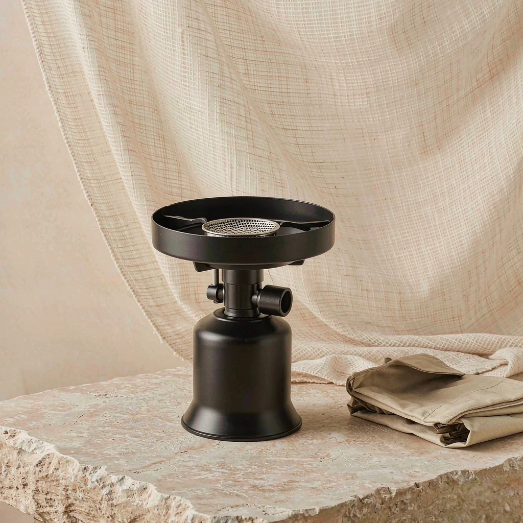 Compact dual-fuel portable gas stove with wind shield ring on a light stone surface